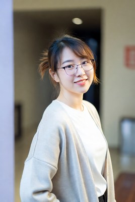 Young woman smiling indoors at a building