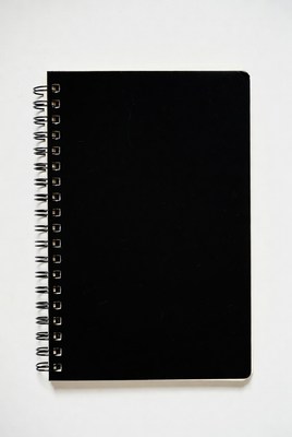 Black Spiral Notebook on White Background