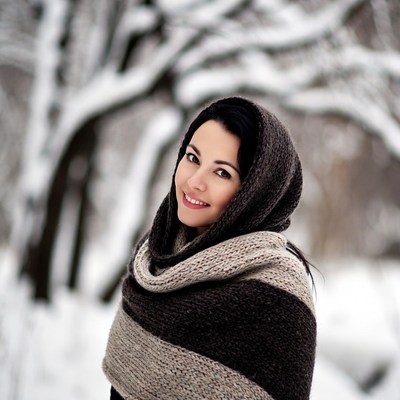 Woman in winter scarf smiles outdoors