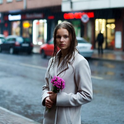 Woman with flowers on rainy street