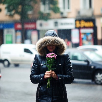 Woman holding flowers in rain