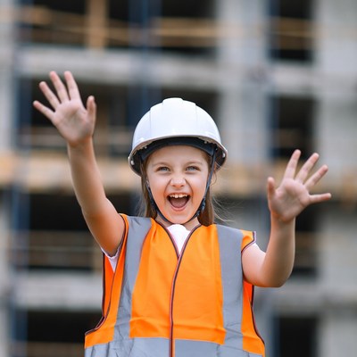 Child at construction site waving hands
