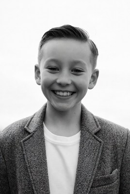 Young boy smiles in a suit