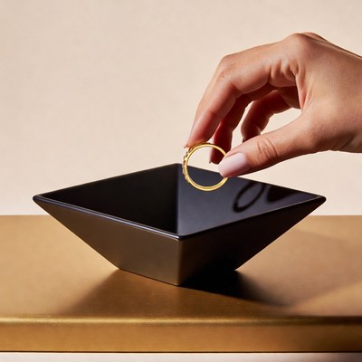Hand placing gold ring in bowl