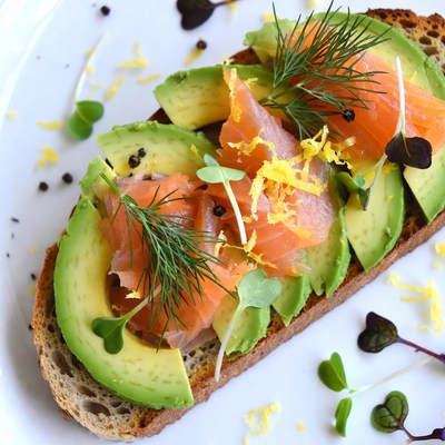 Salmon and avocado toast served on brown bread