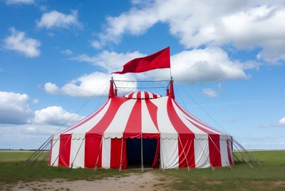 Red and white circus tent in open field