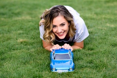 Smiling girl playing with toy car