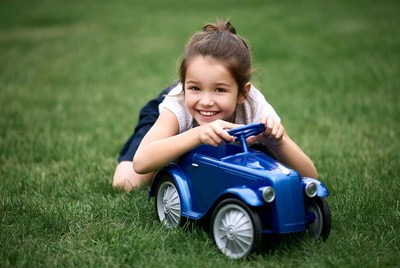 Girl playing with toy car outside