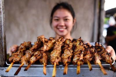 Street vendor sells grilled skewers in the evening