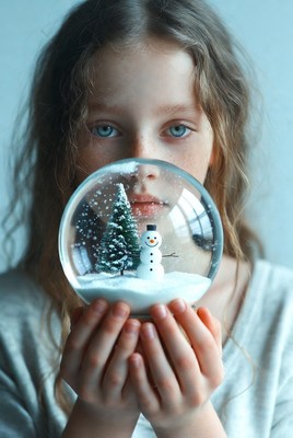 Girl holds snow globe during winter