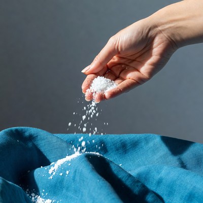 Hand pouring salt onto fabric