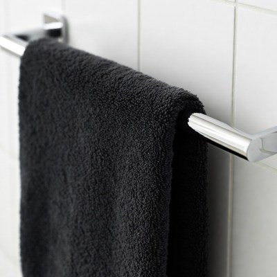 Black towel hanging on rack in bathroom