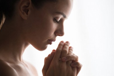 Woman in prayer by window light