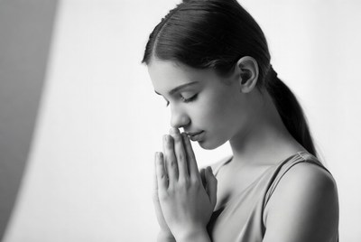 Girl with hands together in prayer