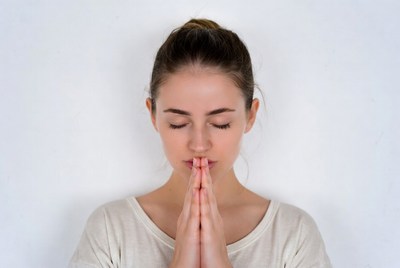Woman practicing mindfulness with hands together