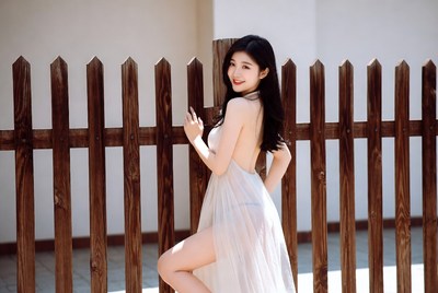 Woman by wooden fence in sunlight