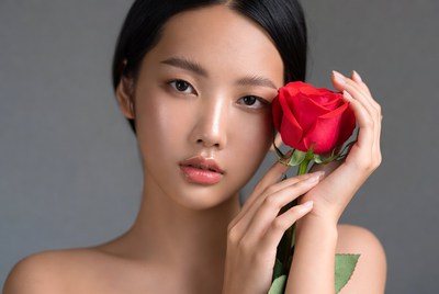 Young woman holds a rose flower