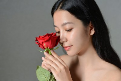 Woman holding red rose close