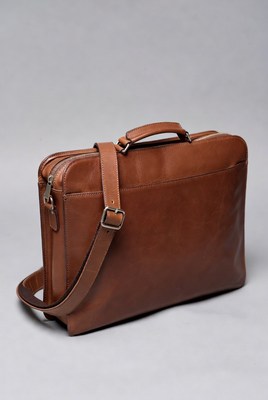 Brown leather bag on gray background