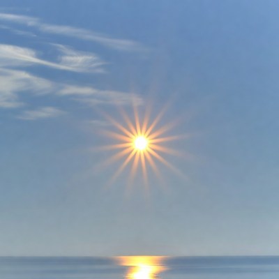 Bright sun over calm ocean water