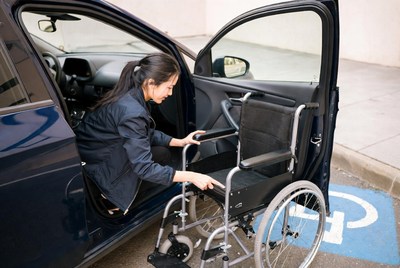 Woman transferring wheelchair from car