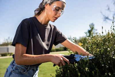 Woman trimming bushes in garden