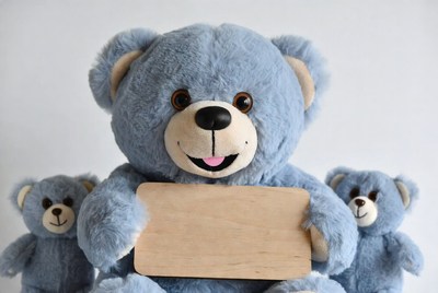 Blue teddy bears with wooden sign