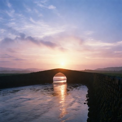 Sunset over stone bridge in countryside