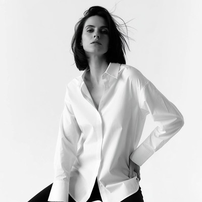 Woman in white shirt poses confidently