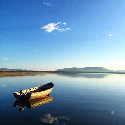 Boat on calm lake at sunset