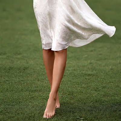 Woman walking barefoot on grass