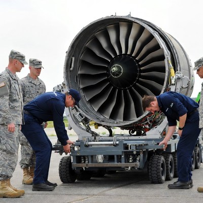 Military team works on jet engine