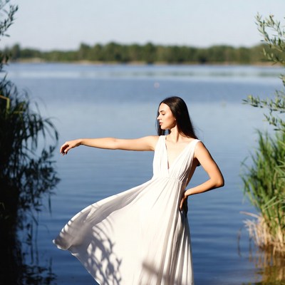 Woman by lake wearing white dress