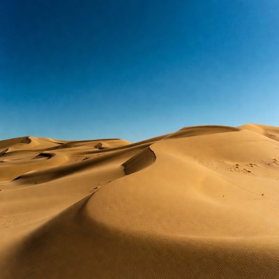 Waves of sand under blue sky