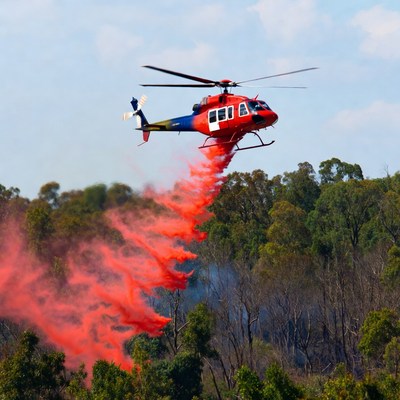 Helicopter drops fire retardant on forest