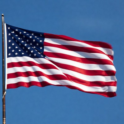 Waving american flag against blue sky