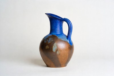 Blue and brown pottery jug on white background