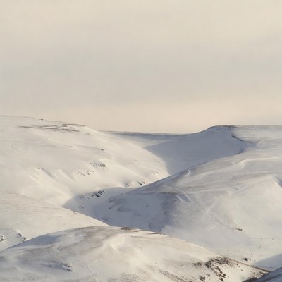 Snowy hills under gray sky