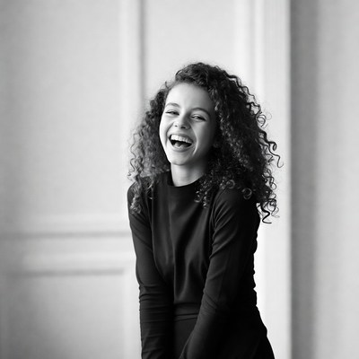 Girl laughing indoors with curly hair