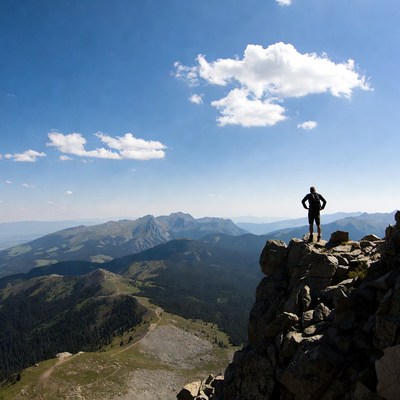 Person stands on mountain peak