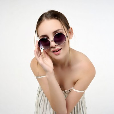 Woman posing in stylish sunglasses indoors