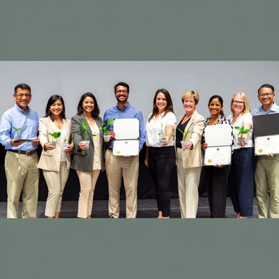 People holding plants and certificates together