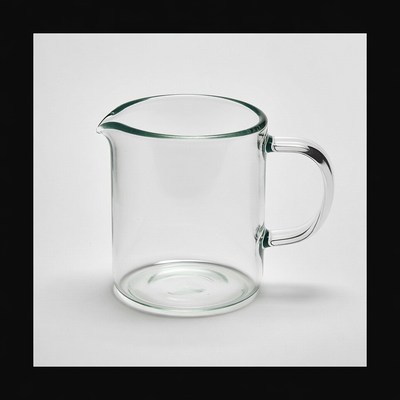 Clear glass measuring jug on plain background