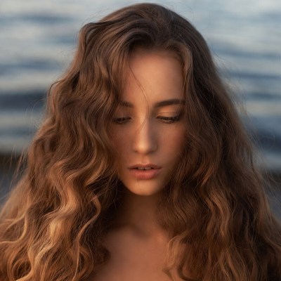 Woman with curly hair by water
