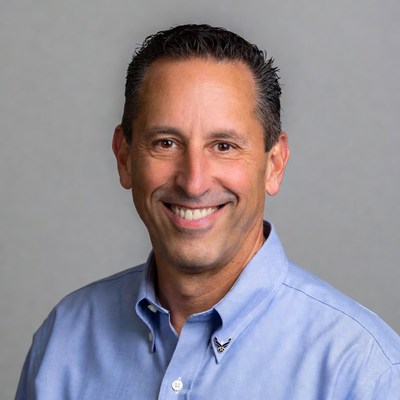 Man smiles with blue shirt indoors