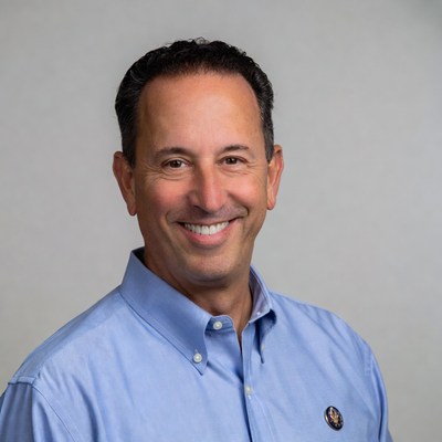 Smiling man in blue shirt with badge