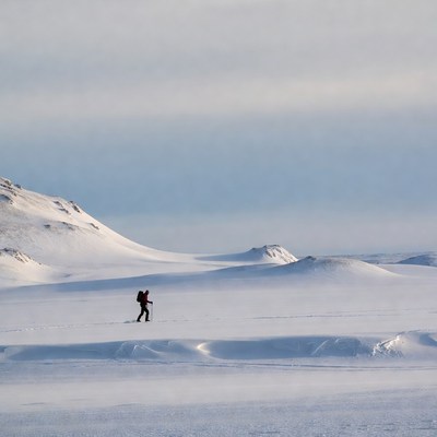 Hiker crossing snowy landscape in winter