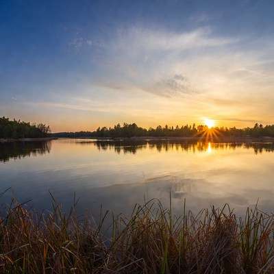 Sunset over calm lake and grass
