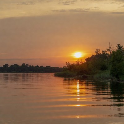 Sunset over calm water at lakeside