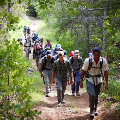 Group of hikers on mountain trail in summer